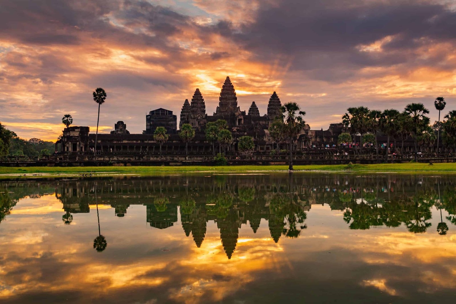 Sunrise behind the towers of Angkor Wat reflected in the moat