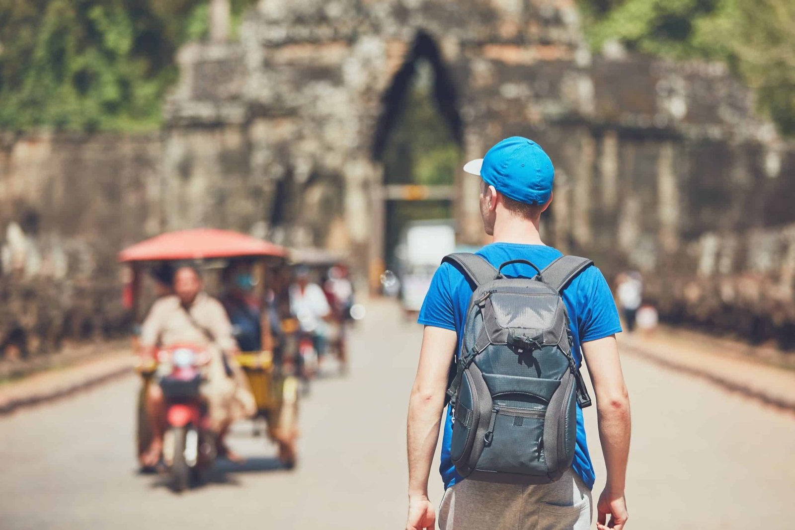 A visitor walking through a temple gallery at Angkor